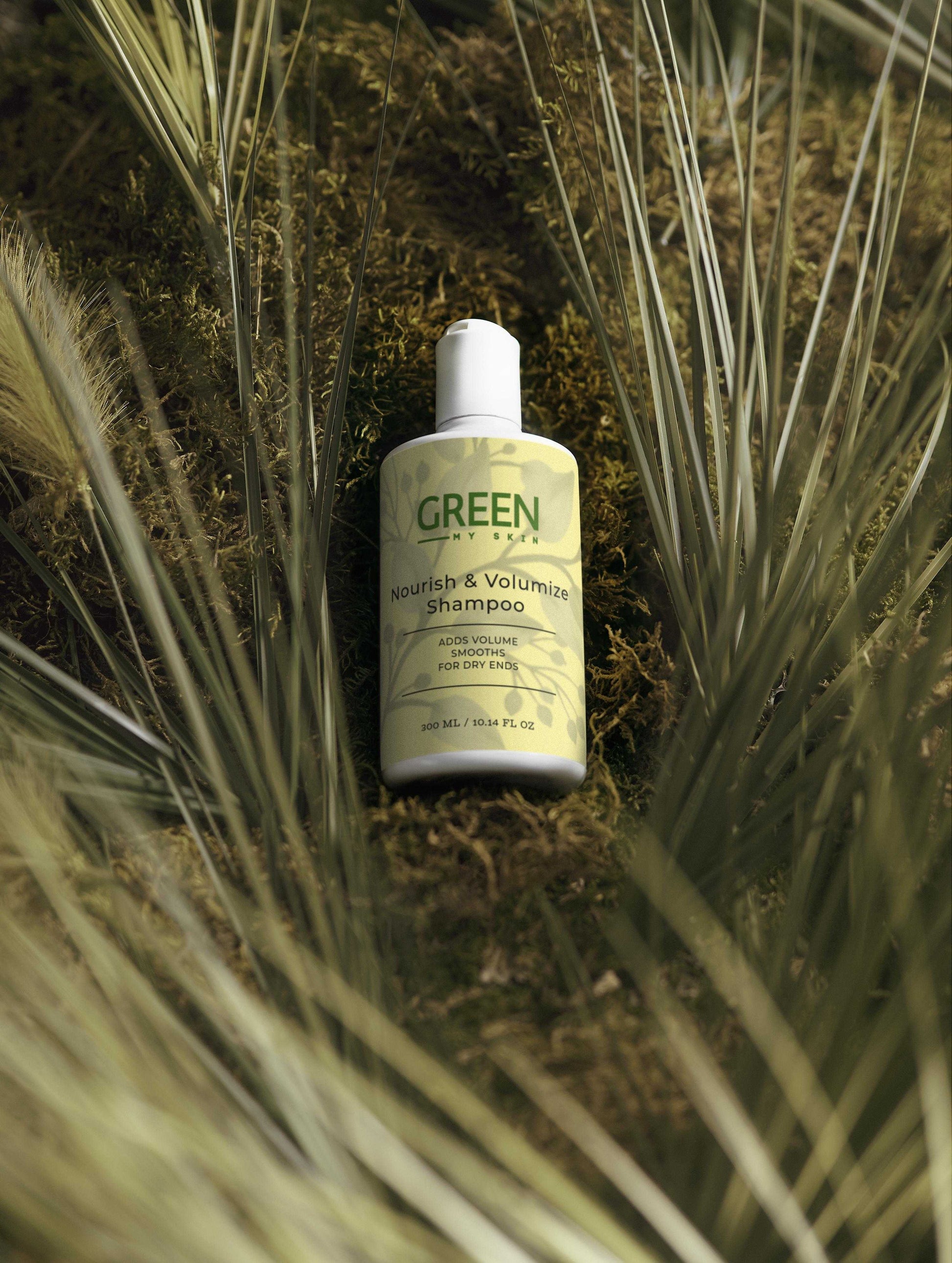 Nourish-and-volumize-shampoo bottle with lush green background, perfect for dry and flat hair.